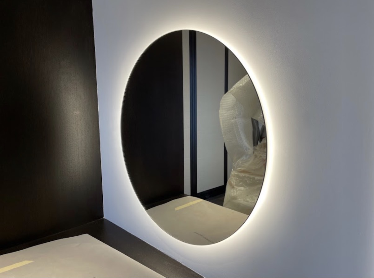 Backlit round LED mirror installation in a bathroom